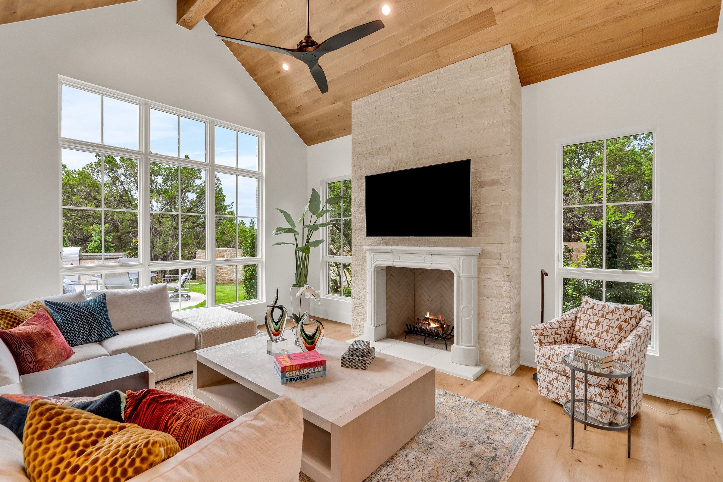 Den with vaulted wood ceiling, cut stone fireplace, and outdoor views at 4300 Amarra Drive